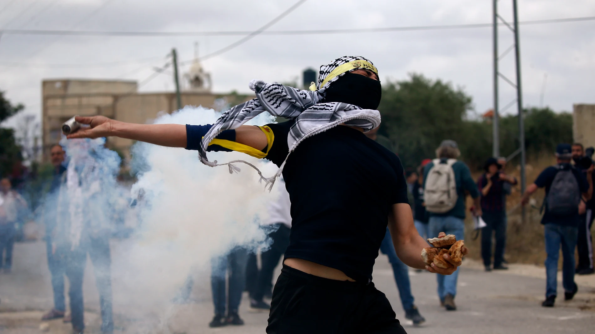 Nablus (-), 19/05/2023.- A Palestinian protester throws back a tear gas grenade during clashes with Israeli troops after a demonstration against Israel's settlements on the lands of Kafr Qaddum village, near the West Bank city of Nablus, 19 May 2023. (Protestas) EFE/EPA/ALAA BADARNEH 16727