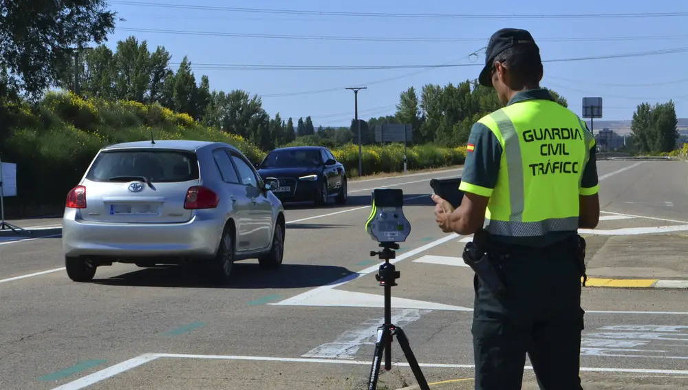 Un agente de la Guardia Civil maneja un radar en una carretera