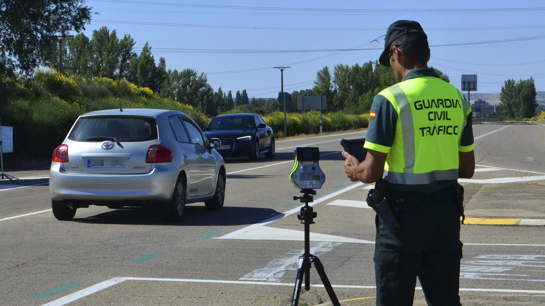 Un agente de la Guardia Civil maneja un radar en una carretera