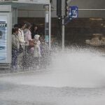 ALICANTE, 24/05/2023.- Varias personas se resguardan de la lluvia en una parada de autobús cuando el Centro de Coordinación de Emergencias ha dado por concluida la situación de preemergencia por lluvias y tormentas nivel naranja en la provincia de Alicante y el interior sur y el litoral de la de Valencia.