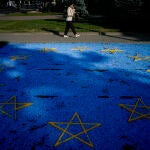Una mujer pasa junto a una bandera instalada en un parque de Chisináu, la capital de Moldavia