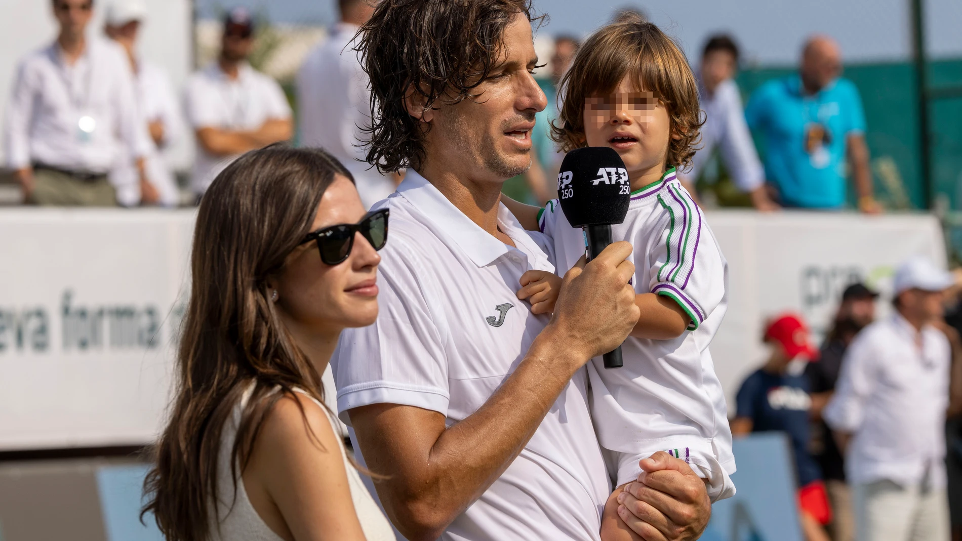 SANTA PONSA(PALMA), 29/06/2023.- Con su hijo Darío en brazos y su mujer Sandra Gago en el centro de la pista central del Mallorca Country Club, escenario del torneo de Mallorca, con las gradas aún pobladas tras el encuentro frente al alemán Yannick Hanfmann, el último de su carrera, Feliciano López oficializó el final de su recorrido profesional, homenajeado por la organización del torneo y la ATP y reconocido por el público presente este jueves.EFE/ Cati Cladera