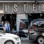 Un trabajador lleva la camilla con el cuerpo de la mujer apuñalada en Tirso de Molina, en Madrid