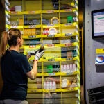 Una trabajadora clasifica los artículos en estanterías para su almacenaje