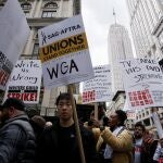 Demonstrators carry signs during a screenwriter's strike in New York City on May 2, 2023. - More than 11,000 Hollywood television and movie writers went on their first strike in 15 years Tuesday, after talks with studios and streamers over pay and working conditions failed to clinch a deal. The strike means late-night shows are expected to grind to a halt immediately, while television series and movies scheduled for release later this year and beyond could face major delays. (Photo by Leonardo Munoz / AFP)
