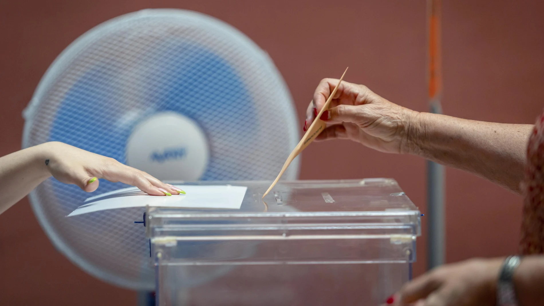 Una votante ejerce su derecho al voto en las elecciones generales ante un ventilador este domingo en el Teatro Rojas de Toledo. Casi 37,5 millones de electores eligen este domingo en las decimosextas elecciones generales a 350 diputados y 208 senadores.