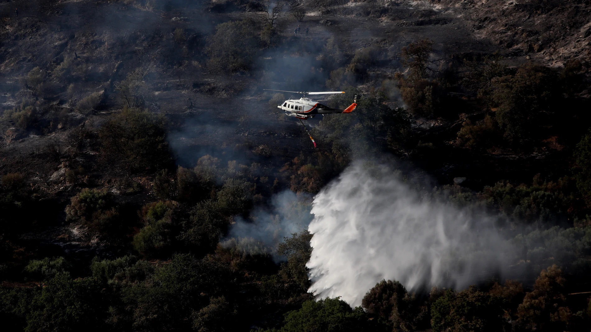 Platanisto (Greece), 25/07/2023.- A firefighting helicopter drops water at the scene of a Canadair CL-215 firefighting aircraft crash which were battling Karystos wildfire, in Platanisto, southern Evia, Greece 25 July 2023.The pilot and co-pilot of a Canadair CL-215 that crashed while fighting a fire in Platanisto, southern Evia, have died. (incendio forestal, Grecia) EFE/EPA/GEORGE VITSARAS