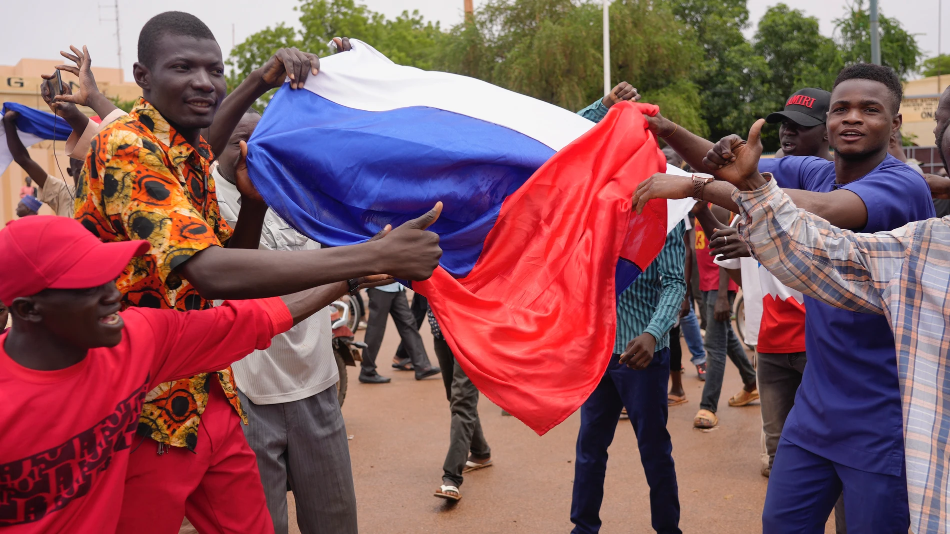 Supporters of mutinous soldiers hold a Russian flag as they demonstrate in Niamey, Niger, Thursday, July 27 2023. Governing bodies in Africa condemned what they characterized as a coup attempt Wednesday against Niger's President Mohamed Bazoum, after members of the presidential guard declared they had seized power in a coup over the West African country's deteriorating security situation. (AP Photo/Sam Mednick)