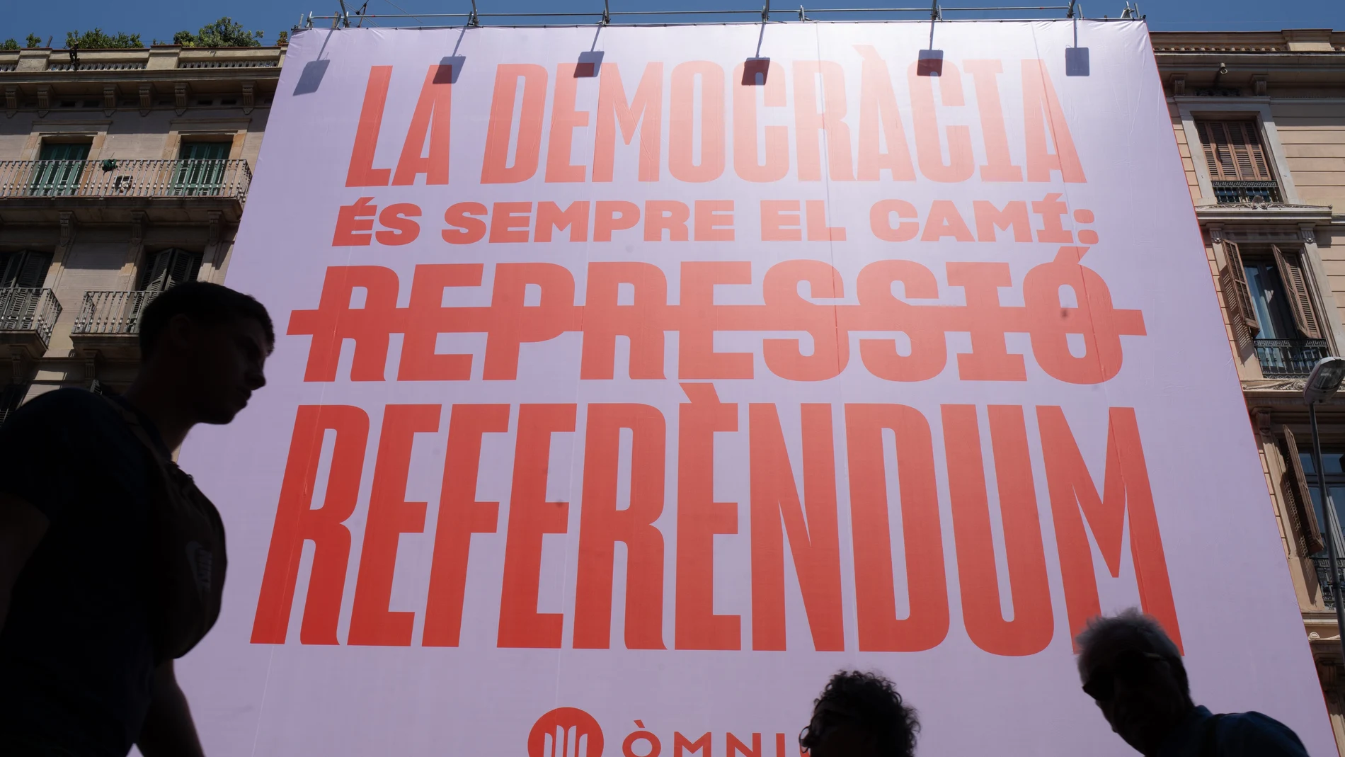 Vista de una pancarta desplegada por parte de Òmnium Cultural, a 28 de julio de 2023, en Barcelona, Catalunya (España). Òmnium Cultural ha desplegado hoy una pancarta gigante donde se lee el mensaje ‘La democracia es el camino: referéndumí, situada en la calle Pelai. 28 JULIO 2023;BARCELONA;CATALUNYA;LONA;ÒMNIUM CULTURAL Europa Press 28/07/2023