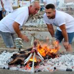 Dos espeteros contemplan las brasas en un chiringuito de la Costa del Sol