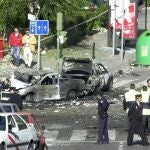 Police officers look at the wreckage of bomb damaged cars after a car bomb exploded killing Supreme Court magistrate Jose Francisco Querol, his driver, bodyguard and wounding some 20 others, in Madrid, Monday October 30. 2000. 