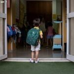 Niño con mochila en la puerta del colegio