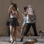 Paseantes se protegen del calor en Córdoba