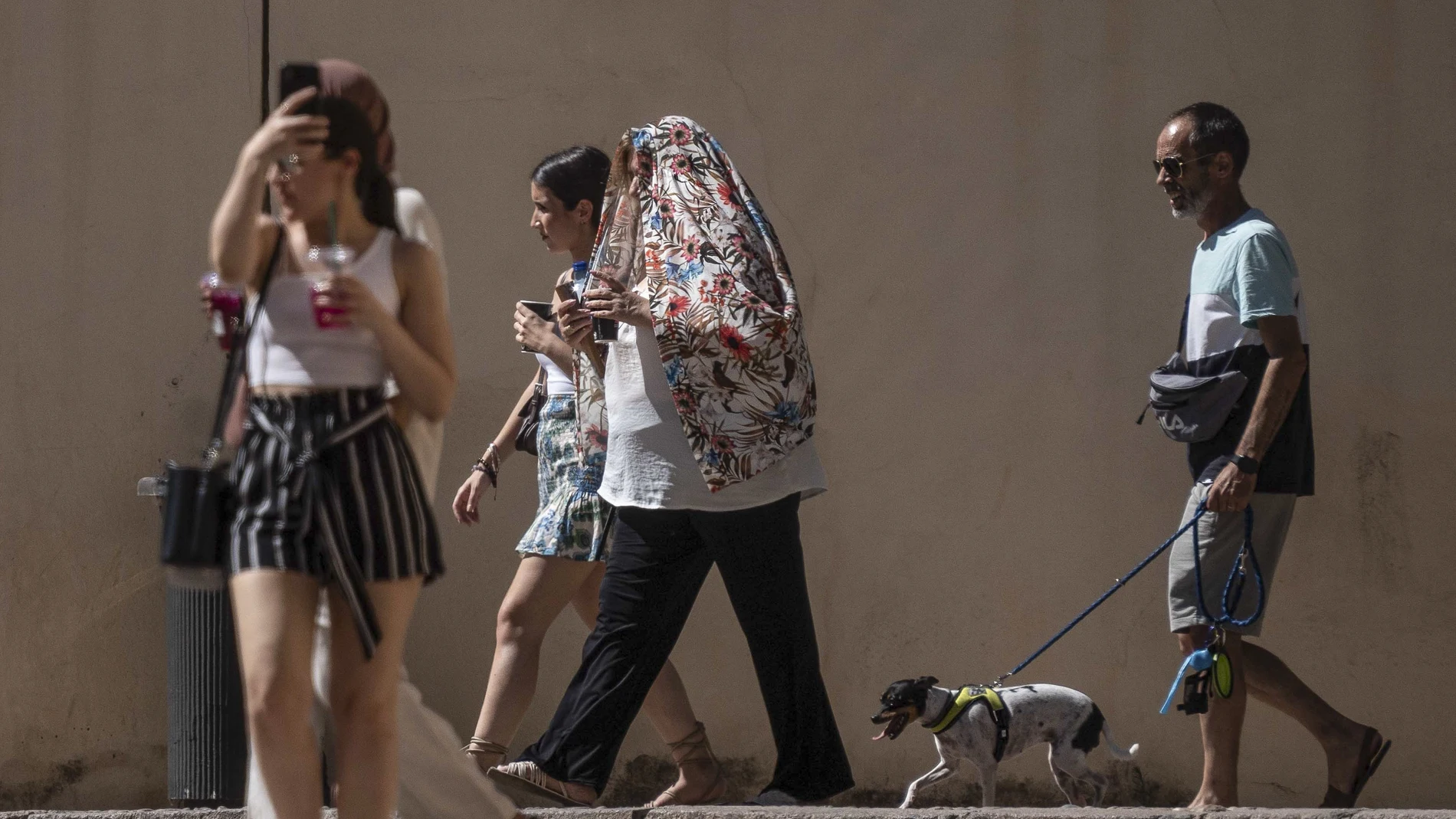 Paseantes se protegen del calor en Córdoba