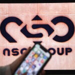Una ilustración fotográfica muestra un teléfono móvil cerca del logotipo de la empresa NSO Group el 9 de febrero de 2022 en la ciudad israelí de Netanya.