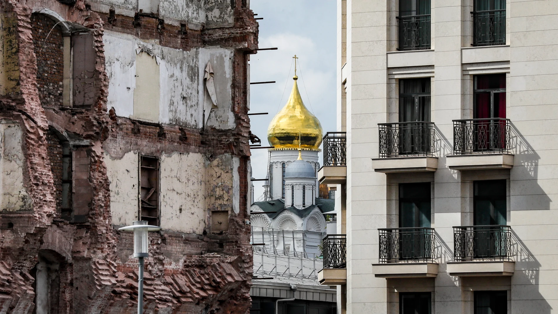 Una iglesis ortdodoxa rusa en Moscú entre un edificio destruido y otro de nueva contrucción