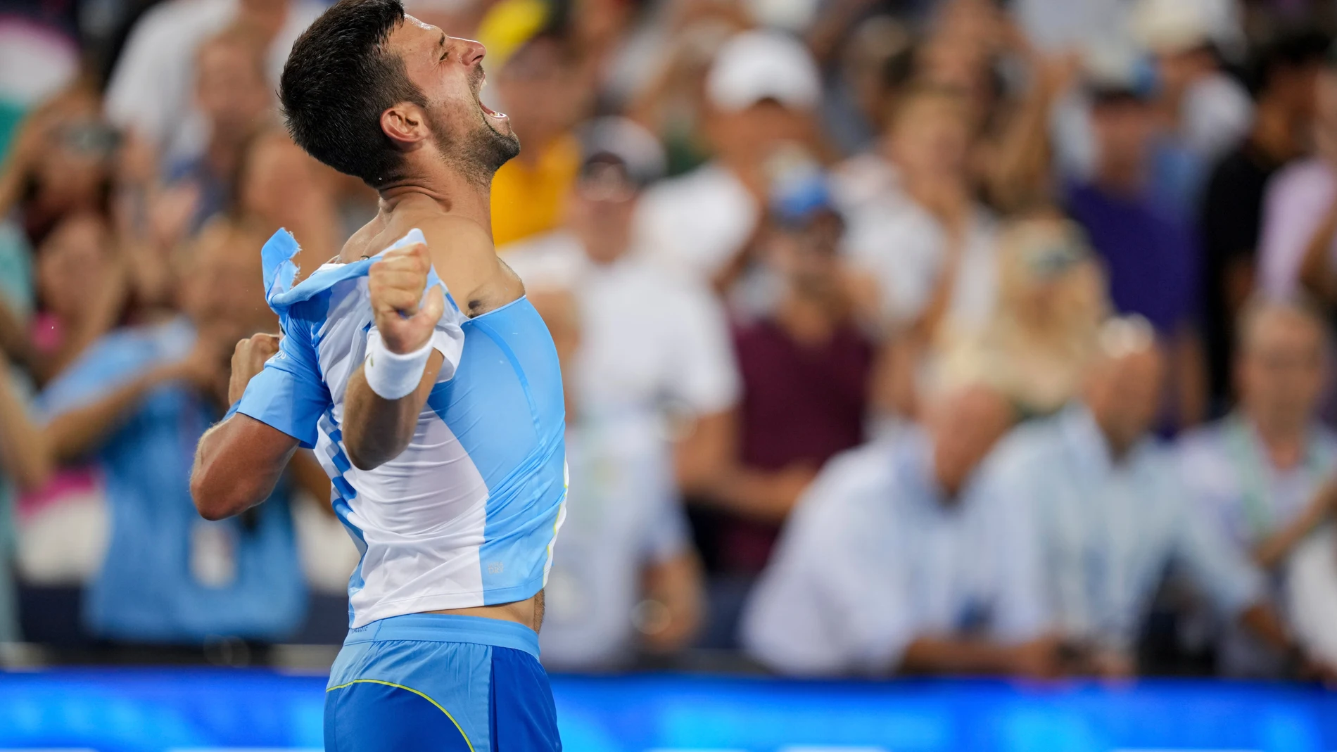 Novak Djokovic, of Serbia, rips his shirt as he celebrates his win against Carlos Alcaraz, of Spain, during the men's singles final of the Western & Southern Open tennis tournament, Sunday, Aug. 20, 2023, in Mason, Ohio. (AP Photo/Aaron Doster)