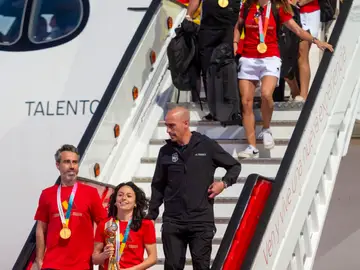 Fiesta de la selección femenina de fútbol MADRID, 21/08/2023.- La jugadora de la selección española de fútbol Ivana Andrés (c-abajo), con el resto de sus compañeras y acompañadas por su entrenador Jorge Vilda y por el presidente de RFEF Luis Rubiales, con el trofeo a su llegada al aeropuerto de Barajas, este lunes en Madrid. EFE/FERNANDO VILLAR