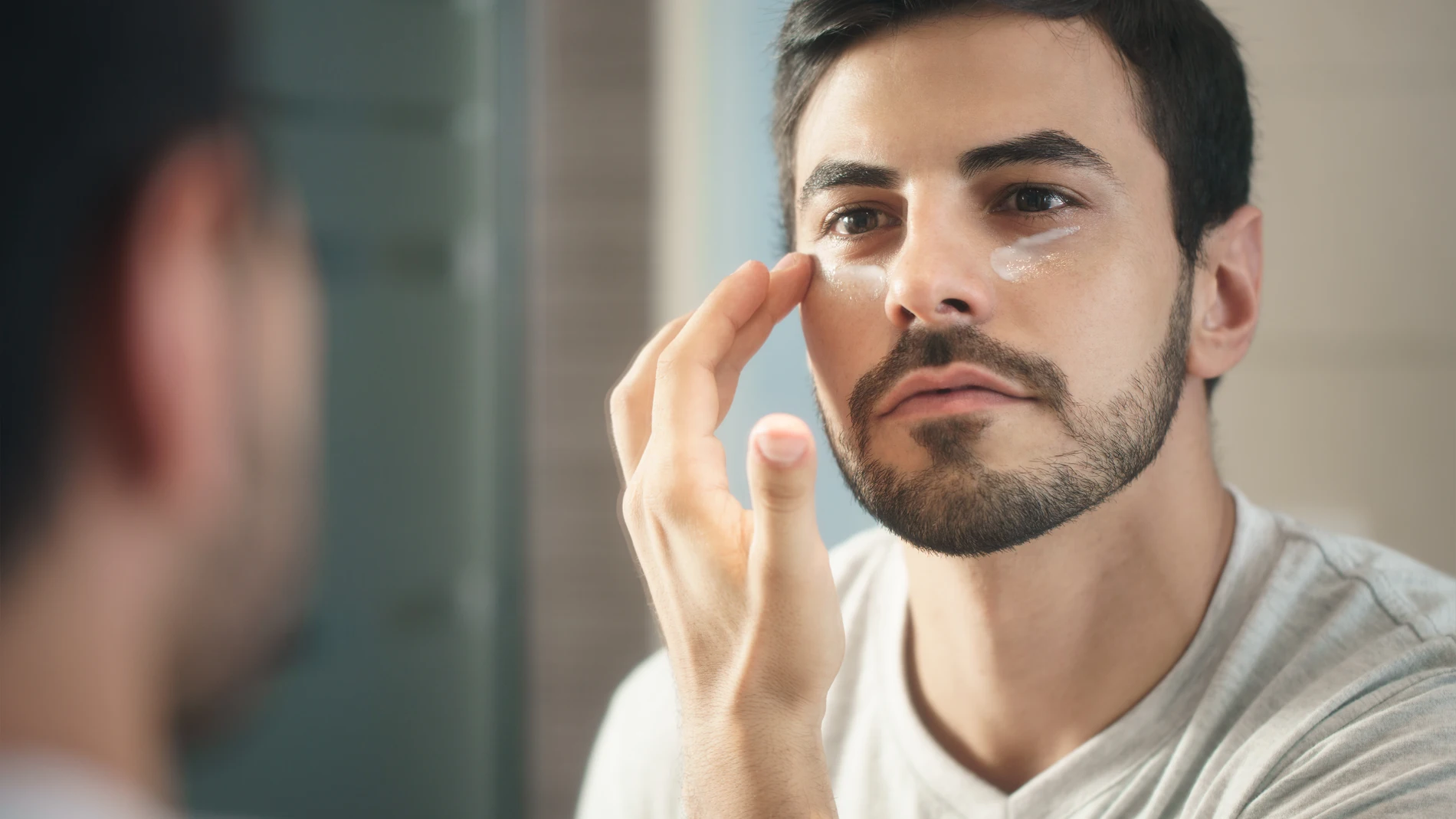 Hombre aplicando crema en el rostro