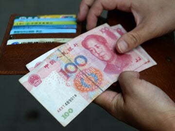 A woman holds Chinese Yuan banknotes. 