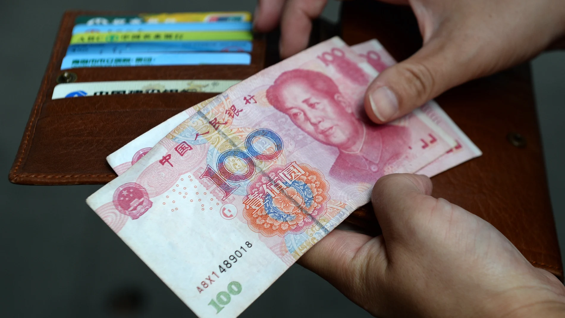 A woman holds Chinese Yuan banknotes.