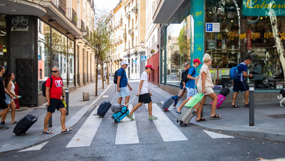 Turistas con maletas por una calle de Madrid
