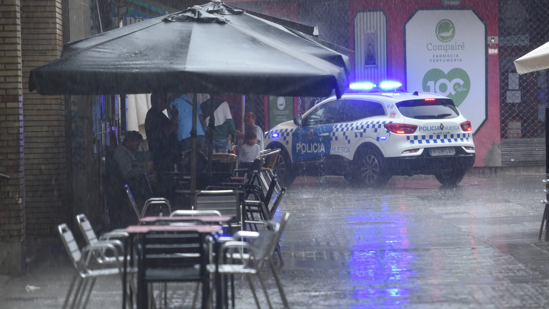 Varias personas se protegen de la lluvia en una terraza, a 2 de septiembre de 2023, en Huesca, Aragón (España). En varias comarcas de Aragón y Navarra, en las que a partir de las seis de la tarde podrían acumularse hasta 30 litros por metro cuadrado en una hora, la AEMET ha activado la alerta naranja por abundantes lluvias y tormentas, que podrían ir acompañadas de granizo. Las comarcas en alerta naranja son Pirineo Oscense, en Huesca; Cinco Villas, en Zaragoza, y Pirineo Navarro, en Navarra....