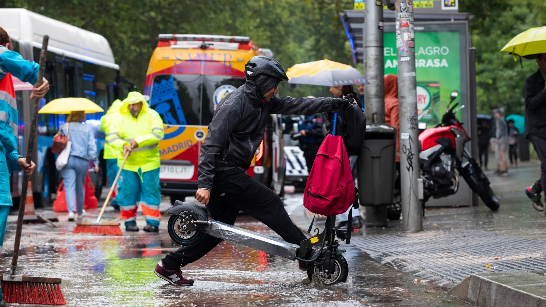 Fuertes lluvias en Madrid por el paso de la Dana. Un joven cruza con su patinete eléctrico por un paso de peatones.© Jesús G. Feria.