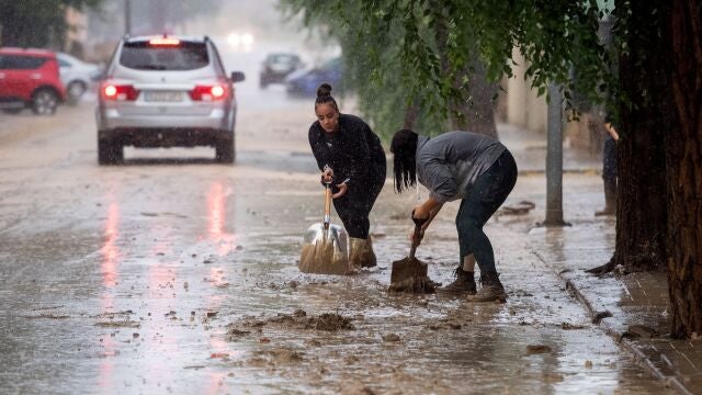 Varias personas retiran el lodo acumulado en Magán (Toledo) a causa de las fuertes lluvias 