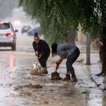 Varias personas retiran el lodo acumulado en Magán (Toledo) a causa de las fuertes lluvias 