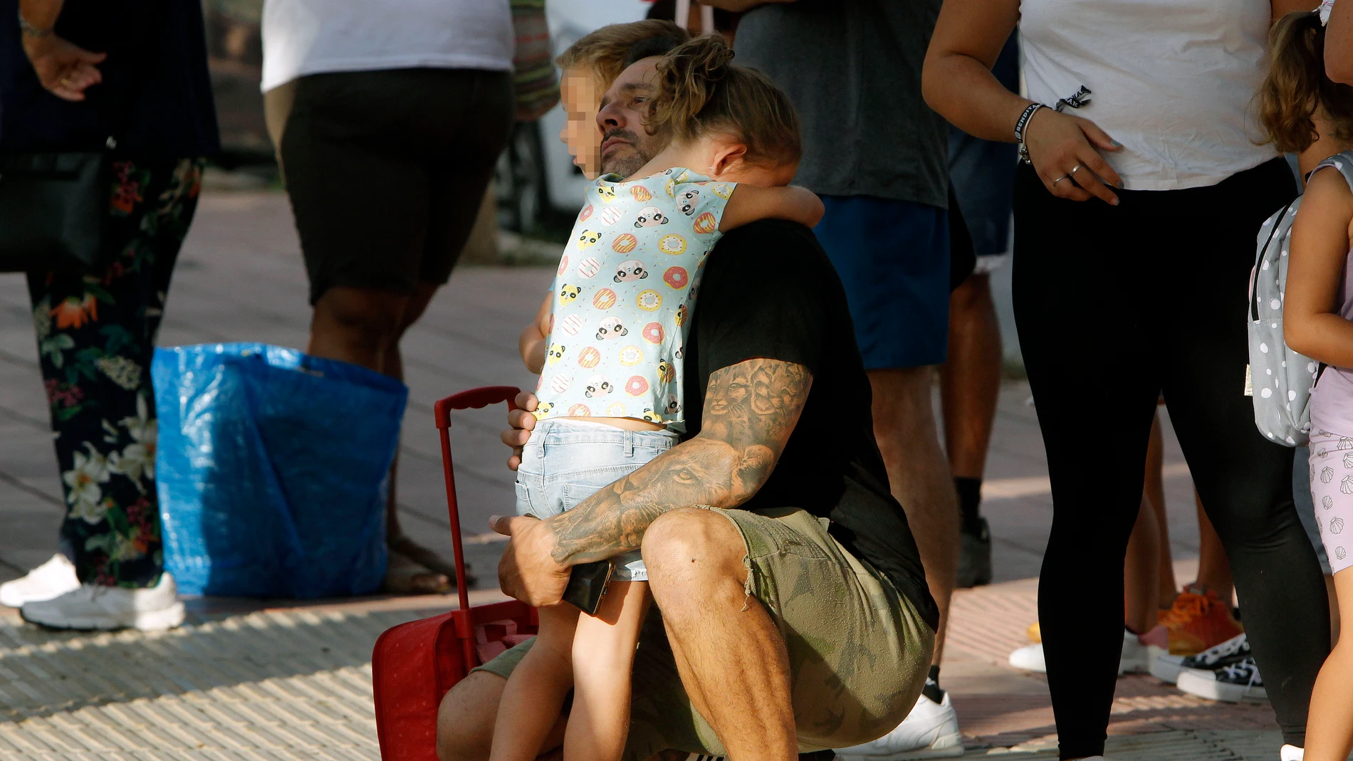 Una niña abraza a su padre en el día de la vuelta al colegio
