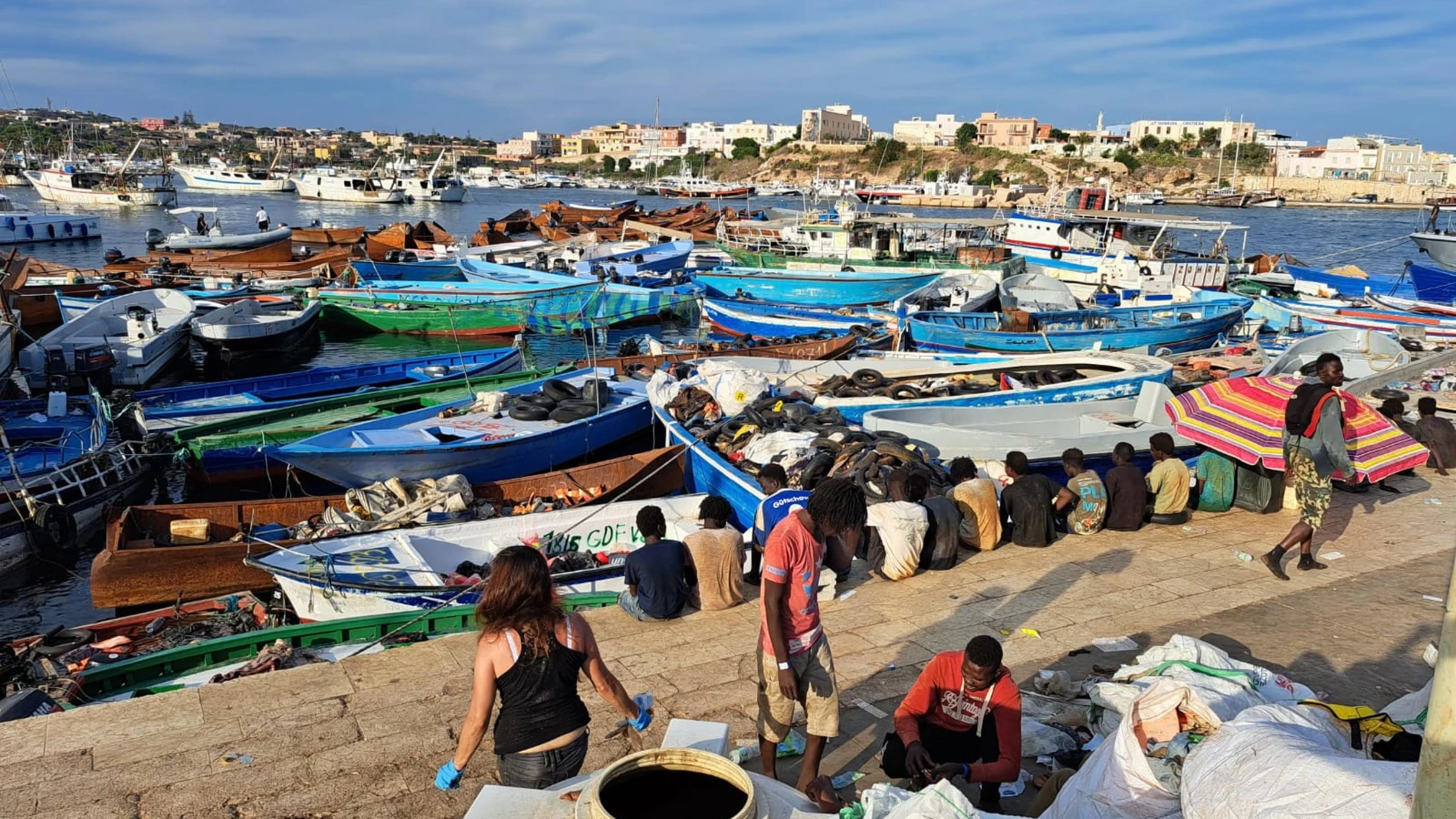 Lampedusa (Italy), 13/09/2023.- A group of migrants wait on the island of Lampedusa as Italian authorities prepare for transferring people following new arrivals, Italy, 13 September 2023. More than 6,790 migrants were on the Italian island on 13 September after a record arrival of 6,402 people in two days. The Prefecture of Agrigento has arranged for a ferry to pick up around 700 people from Lampedusa to Porto Empedocle, while another 180 being transferred by an IOM flight. (Italia) EFE/EPA/...