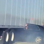 Un coche queda atrapado debajo de un camión y es arrastrado por la carretera