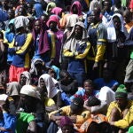 Un inmigrante espera a ser transferido desde Lampedusa tras un récord de llegadas