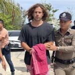 A Thai police officer escorts Spanish Daniel Sancho Bronchalo on suspicion of murdering and dismembering a Colombian surgeon from Koh Phagnan island to Koh Samui Island court, southern Thailand, Monday, Aug. 7, 2023. Sancho, the son of two Spanish film stars, has been arrested in Thailand on suspicion of murdering and dismembering Edwin Arrieta Arteaga on a tourist island, police said. Sancho was taken from Koh Phagnan, where the remains of the Colombian surgeon were found, to another island, Samui, where he is being held, Surat Thani provincial police commander Saranyu Chamnanrat said Tuesday. (AP Photo/Somkeat Ruksaman)