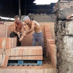 Dos operarios trabajan en el horno árabe del tejar de los hermanos Lobillo en Vélez-Málaga