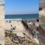 Mexicanos cruzando el muro fronterizo entre México y Estados Unidos