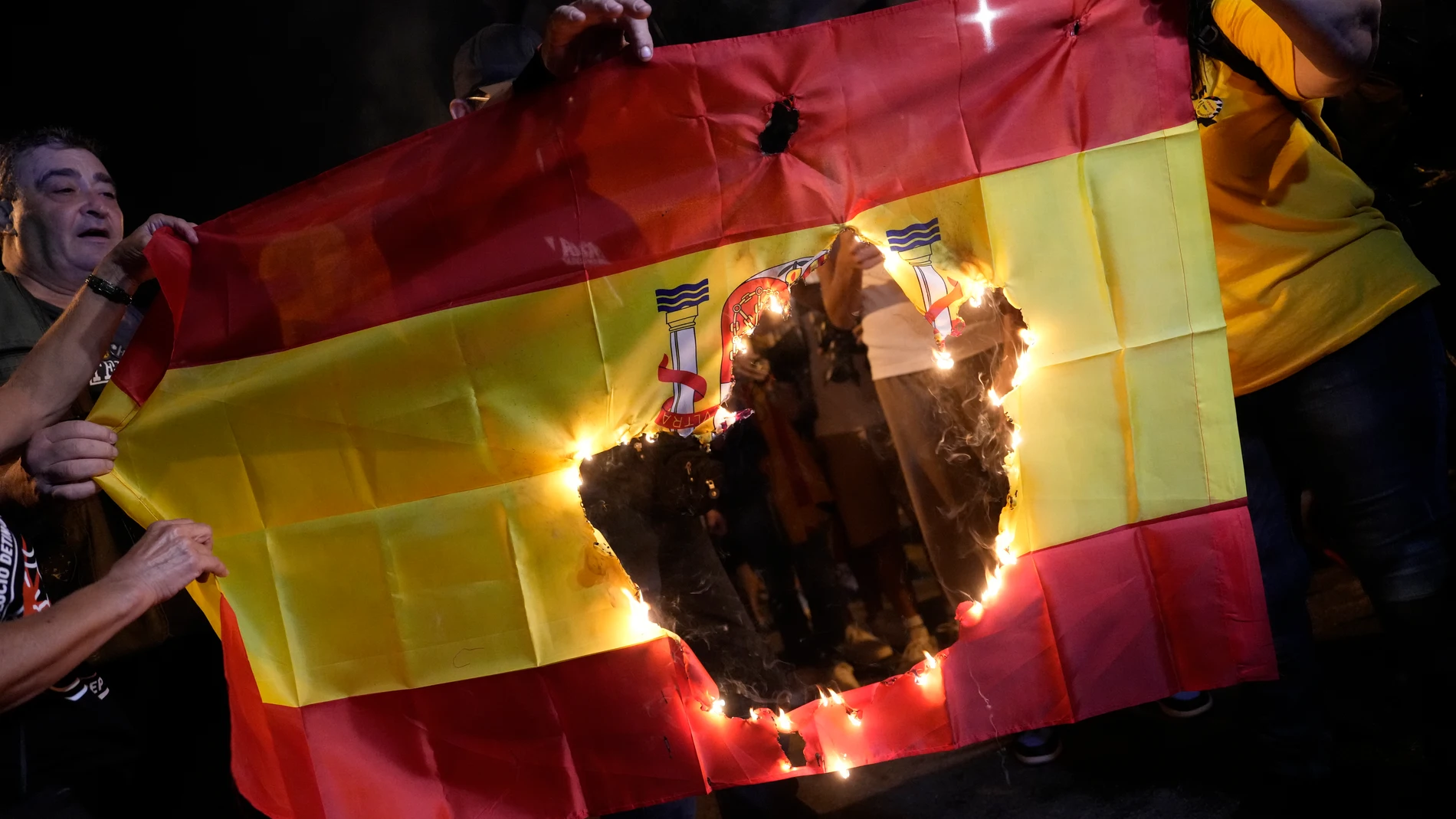 BARCELONA, 01/10/2023.- Manifestantes queman una bandera de España durante la concentración en la que las entidades independentistas han reunido este domingo en la capital catalana a unas 4.500 personas, según datos de la Guardia Urbana de Barcelona, para conmemorar el sexto aniversario del referéndum unilateral del 1 de octubre, marcado por las negociaciones para la investidura. EFE/Enric Fontcuberta Manifestación por el sexto aniversario del referéndum del 1 de octubre celebrada este doming...