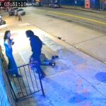Momento en el que un desconocido increpa a la novia del activista Ryan Carson, que yace tendido en el suelo tras ser apuñalado
