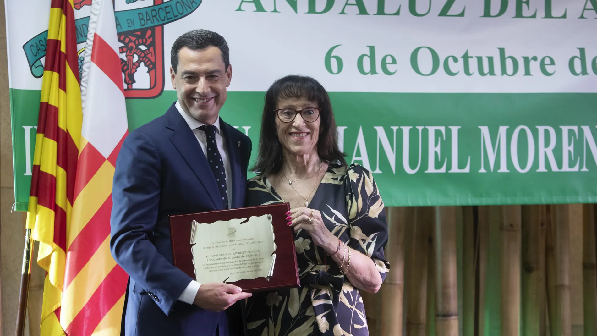 Juanma Moreno recibe de la mano de la presidenta de la Casa de Andalucía Paquita Marín el reconocimiento 'Andaluz del Año 2023