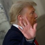 Former US President Donald J. Trump gestures to the media during a short recess on the third day of his civil fraud trial in New York.