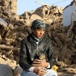 An Afghan boy hold his cat, as he sits in a courtyard of his destroyed home after an earthquake in Zenda Jan district in Herat province, of western Afghanistan, Sunday, Oct. 8, 2023.