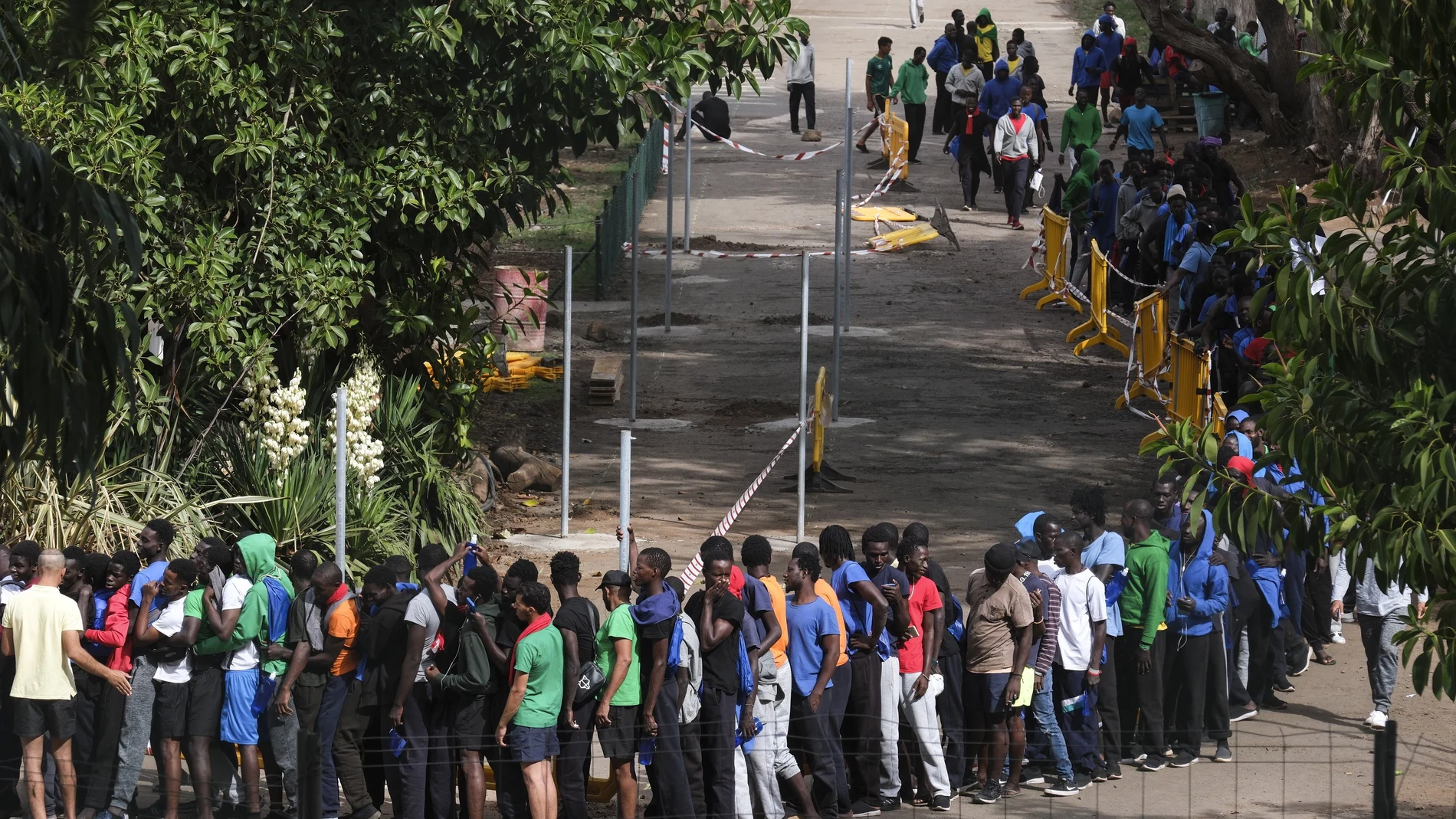 Varias decenas de inmigrantes hacen cola en el interior centro de acogida de Las Raíces, en La Laguna (Tenerife), donde han sido alojados buena parte de las personas que han llegado en los últimos días en cayuco a El Hierro y Tenerife.
