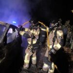 Los bomberos de Ibiza apagan el incendio en el todoterreno negro Land Rover usado este lunes por dos encapuchados para intentar liberar a un preso en Ibiza