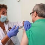 Una sanitaria pone una vacuna a un hombre
