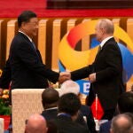 El presidente ruso, Vladímir Putin (d), y el presidente chino, Xi Jinping (i), se estrechan la mano