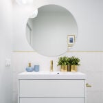 Cuarto de baño ordenado con espejo redondo 