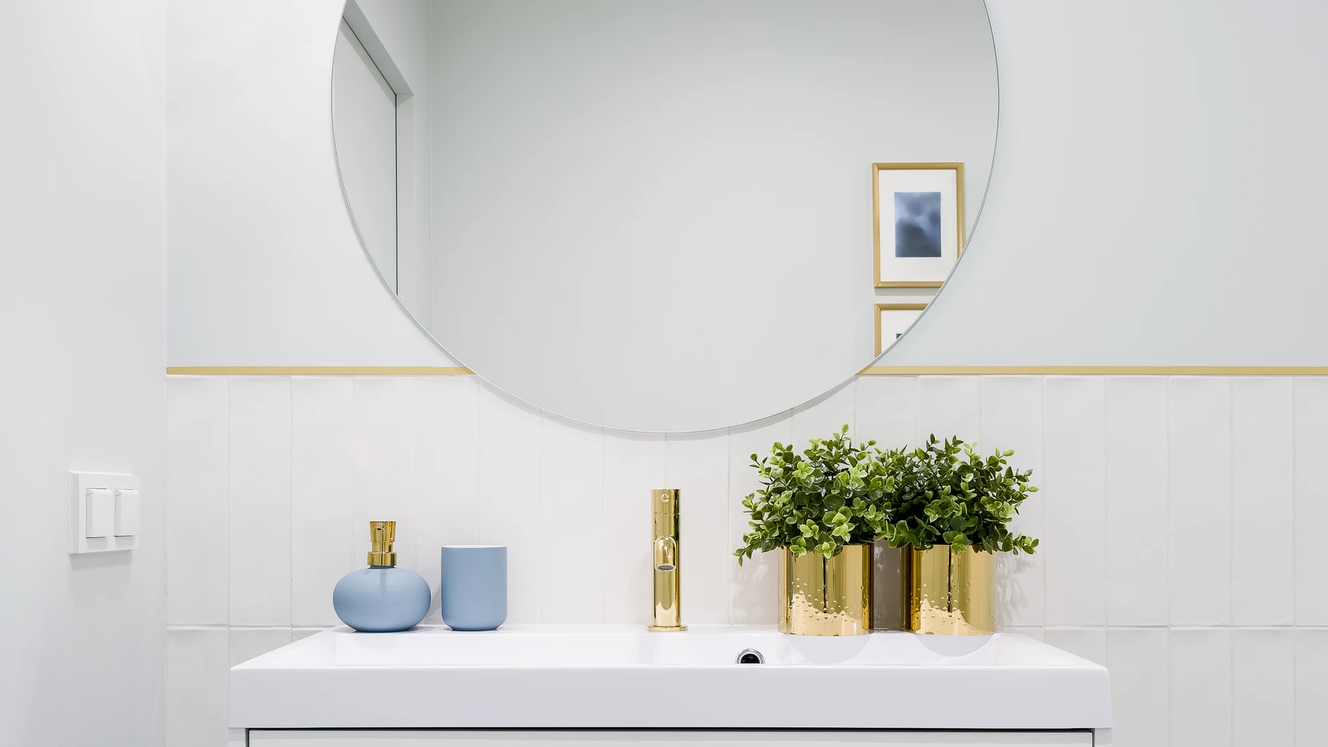 Cuarto de baño ordenado con espejo redondo