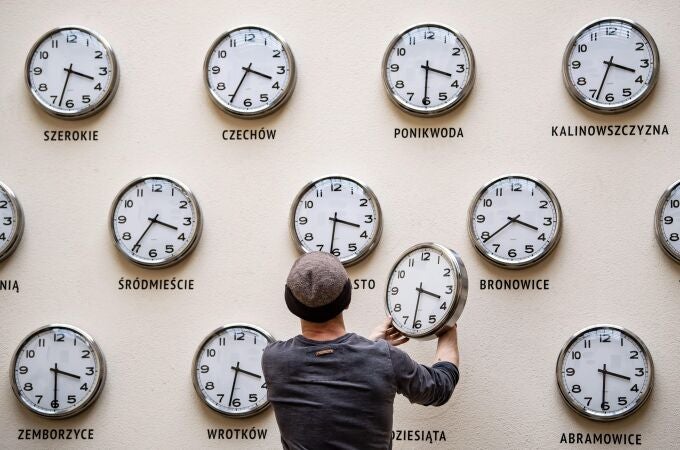 Kamil R. Filipowski cambia la batería de un reloj de pared que forma parte de la obra "Time for culture" (lit. Tiempo de cultura) en el Centro de Cultura este viernes de Lublín, Polonia. En la madrugada del 30 al 31 de marzo, los relojes polacos cambiaran su hora para adaptar el horario de verano