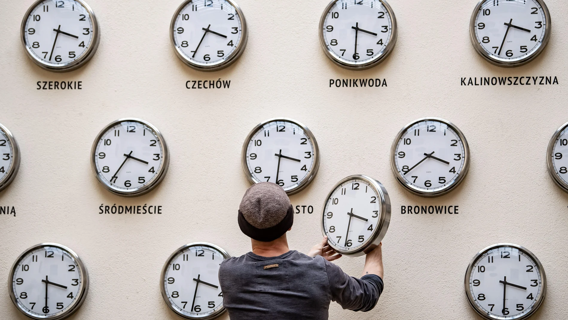 Kamil R. Filipowski cambia la batería de un reloj de pared que forma parte de la obra "Time for culture" (lit. Tiempo de cultura) en el Centro de Cultura este viernes de Lublín, Polonia. En la madrugada del 30 al 31 de marzo, los relojes polacos cambiaran su hora para adaptar el horario de verano